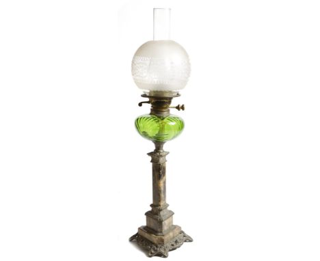 An Art Nouveau oil lamp, with a frosted glass globe shade, above a green glass reservoir, the triform marble column stem on a