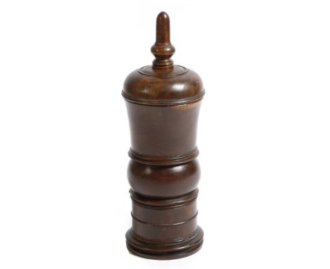 A George III treen lignum vitae coffee grinder, the lid with a stylised acorn finial, above a ring turned body, with a detach