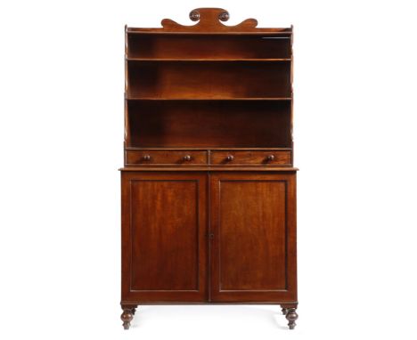 A George IV mahogany waterfall bookcase cabinet, with a shaped scroll surmount, above an open waterfall bookcase, fitted with