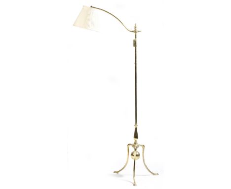 A brass standard lamp in 18th century style, with an adjustable arm, on a baluster stem and tripod supports, late 19th / earl