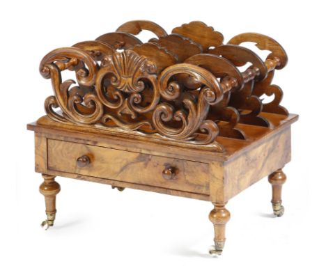 A Victorian walnut Canterbury, carved with scrolls, with three divisions, fitted with a drawer, on ceramic castors, 36.8cm hi