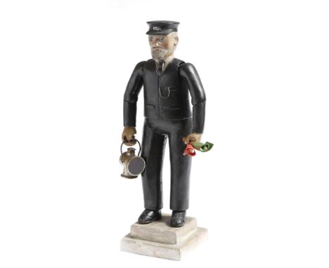 A folk art painted wood figure of a train conductor, wearing a peaked cap with initials 'MR' for Midlands Railway, carrying a