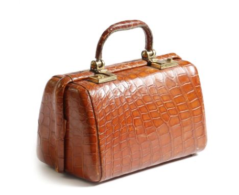 A vintage crocodile leather lady's handbag, with brass hinges and locks, stamped 'REGD DESIGN NO. 854995', with a silk lined 