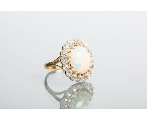 OPAL AND DIAMOND CLUSTER RING
with a large oval cabochon opal measuring 13.34 x 11.48mm, surrounded by old cut diamonds, mark