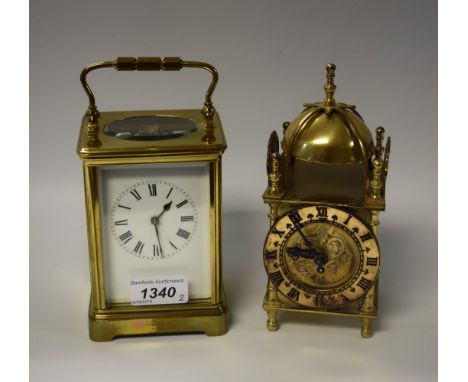 An early 20th century large lacquered brass carriage timepiece, Roman numerals on white rectangular dial, 19cm over handle; a