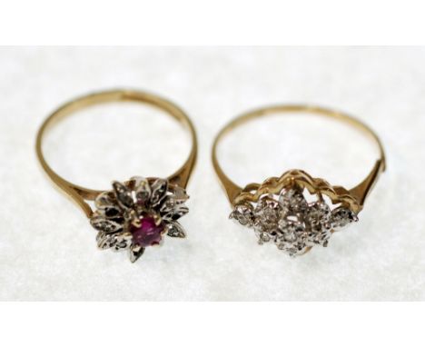 A GOLD FLORET RING set with a central ruby coloured stone within a surround of twelve diamond set petals, 2.0 gms gross, and 