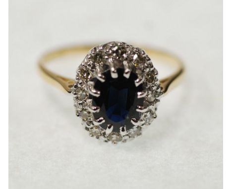 SAPPHIRE AND DIAMOND CLUSTER RING, claw set with oval mixed cut sapphire and a surround of twelve single cut diamonds, 0.12ct