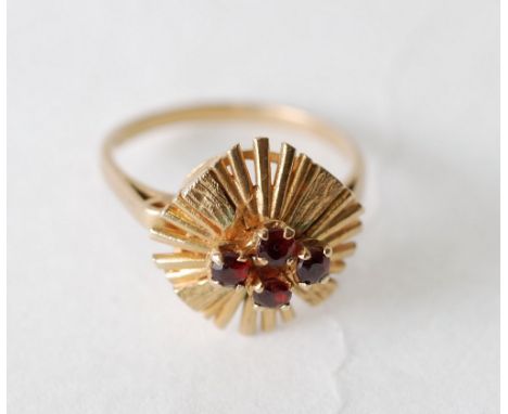 GARNET SET RING, centre set with four round cut garnet with textured sunburst gold surround, size S, London, 4.5g