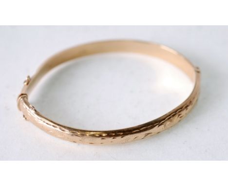 9CT GOLD HINGE OPENING BANGLE, with foliate engraved front, Birmingham 1989, 8g