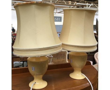 A pair of pale yellow ceramic baluster form table lamps, with shades, each 44cmH to top of shade 