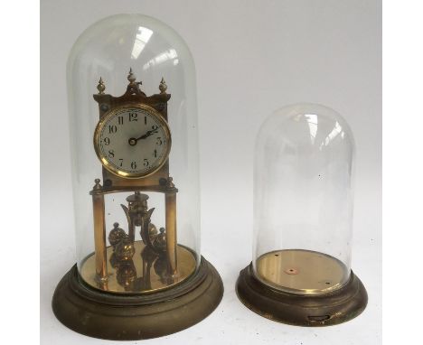 A gilt metal mantel clock in glass cloche, together with one other glass cloche 