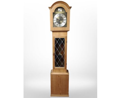 A reproduction oak tempus fugit longcase clock, with pendulum and weights, height 195cm.