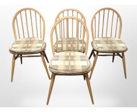 A set of four Ercol elm and beech spindle back dining chairs with seat pads.