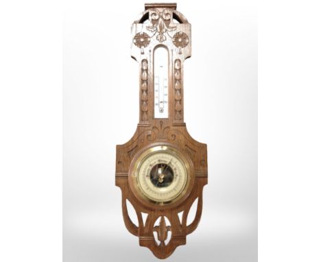 A carved oak barometer/thermometer, length 53cm.
