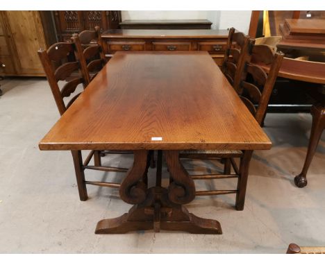 A reproduction oak dining suite in the style of Titchmarsh &amp; Goodwin, comprising refectory dining table on pierced shaped