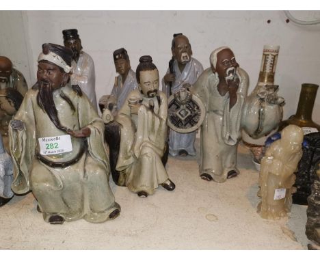 Six Chinese stoneware figures of sages, sitting and standing, with crackle glaze robes and bisque faces, eights 22 - 25 cm 