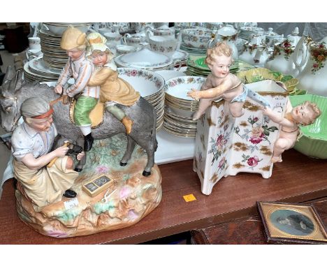 A 19th century bisque group Blacksmith shoeing a donkey; a Victorian cherub encrusted vase; a plaster group of modern vases 