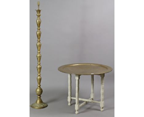 An eastern brass engraved circular tray-top occasional table on a white painted wooden fold-away stand, 74cm diameter x 54.75