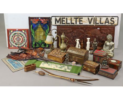 An ethnic carved wooden panel depicting a village scene with numerous figures to the foreground, 92cm x 41cm; together with a