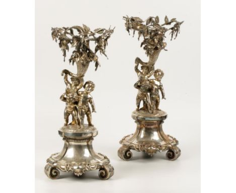 A PAIR OF VICTORIAN FIGURAL CENTREPIECES, each modelled in the form of three cavorting putti holding aloft a cornucopia issui