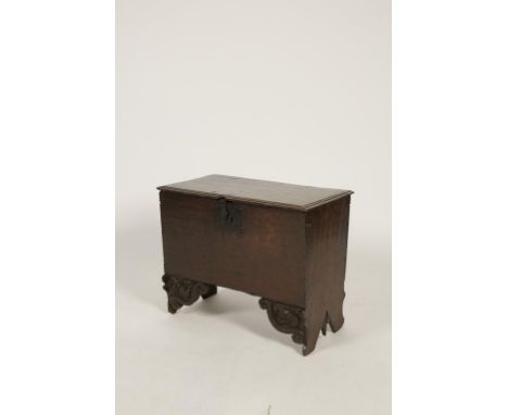 A RARE "ELIZABETHAN" OAK BOARDED CHILDS CHEST with a moulded lid over a plain front with iron lock plates and with two heavy 