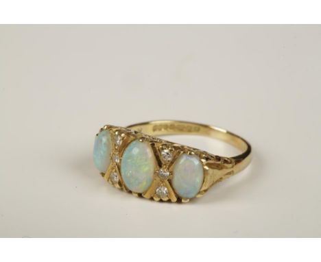 AN OPAL AND DIAMOND 'GYPSY' RING, set with three oval graduated opal cabochons, between six diamond spacers, in a heavy scrol