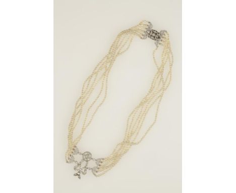 A BELLE EPOQUE NATURAL PEARL AND DIAMOND CHOKER, formed from six rows of natural seed pearls each c. 2.38mm, united with a ce
