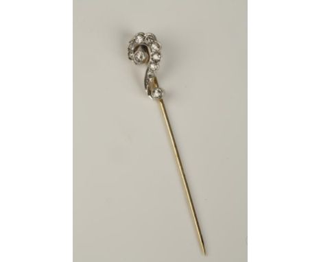 AN EDWARDIAN DIAMOND SCROLL STICK PIN, the scroll terminal rubover set with 10 graduated round-cut diamonds, in unmarked yell