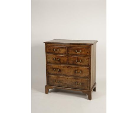 A QUEEN ANNE WALNUT CHEST OF DRAWERS, the rectangular top with broad crossbanding and moulded border above two short and thre