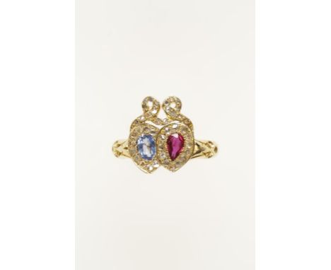 A VICTORIAN ENTWINED HEARTS RING, rubover-set to the centre with an oval-cut pale blue sapphire and a pear-cut ruby, within r