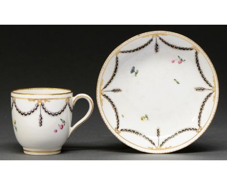 A Derby coffee cup and saucer, c1770-1777, enamelled in black and grey with husk festoons and polychrome sprigs, gilt dentil 