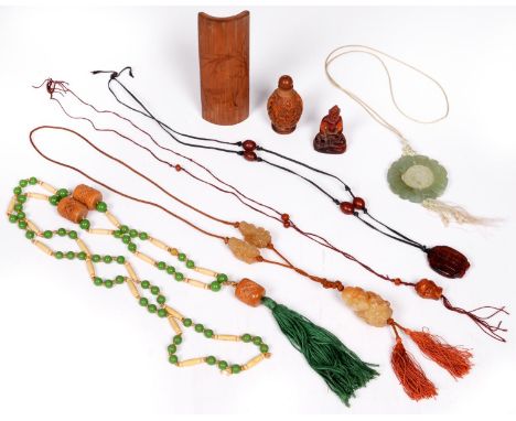 A Chinese bamboo wrist rest, several carved jade pendants, a carved walnut snuff bottle, etc, wrist rest 13cm l  As a lot in 