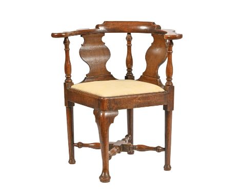 A George III oak and fruitwood corner chair, the arm bow with baluster uprights and spoon splats, on cabriole forelegs with s