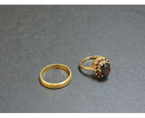 A 9ct gold oval garnet cluster ring, and a 22ct gold wedding ring