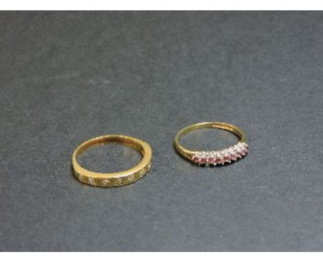 A diamond set half eternity ring, tested as approximately 18ct gold, and a 9ct gold ruby and diamond three row ring