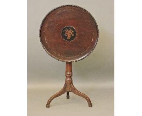 A mahogany tripod table, the circular top with inlaid decoration and a carved border