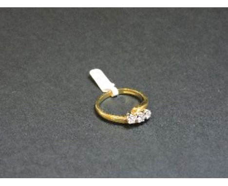 An 18ct yellow and white gold three stone diamond crossover ring