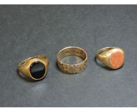 A gentleman's 9ct gold onyx signet ring, a gentleman's 9ct gold synthetic goldstone signet ring, and a 9ct gold engraved wedd