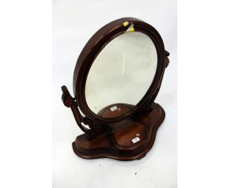 A LATE VICTORIAN MAHOGANY DRESSING TABLE MIRROR with oval mirror plate on pierced and carved supports, serpentine fronted box