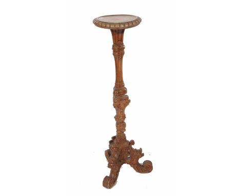 AN ANTIQUE ITALIAN FRUITWOOD TORCHIERE with circular top on triangular section carved support and with scrolling tripod base,