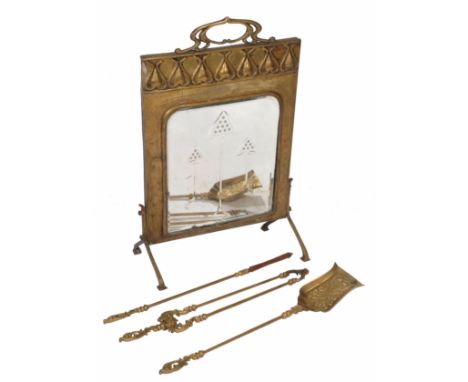 AN ART NOUVEAU BRASS FIRE SCREEN set with mirrored plate and standing on shaped legs together with a set of brass fire tools,