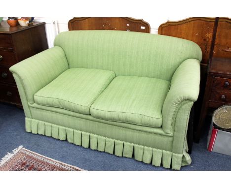 A GREEN UPHOLSTERED SOFA with scrolling arms standing on square tapering legs terminating in castors, 170cm wide