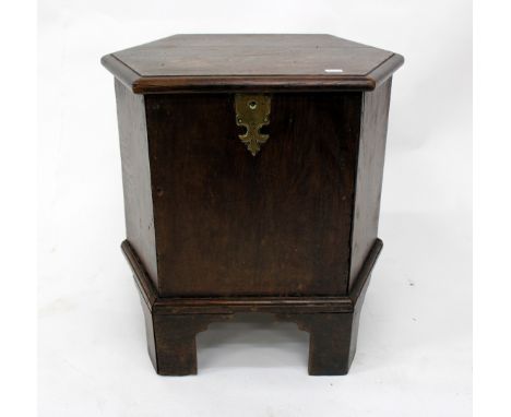AN ANTIQUE OAK HEXAGONAL CLOSE STOOL with lifting lid and standing on bracket feet, 48.5cm wide x 49cm high