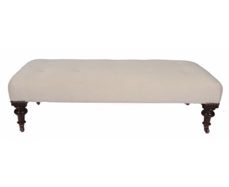 A LARGE CREAM BUTTON UPHOLSTERED LOW STOOL standing on turned tapering  legs terminating in ceramic castors, approx. 150cm lo