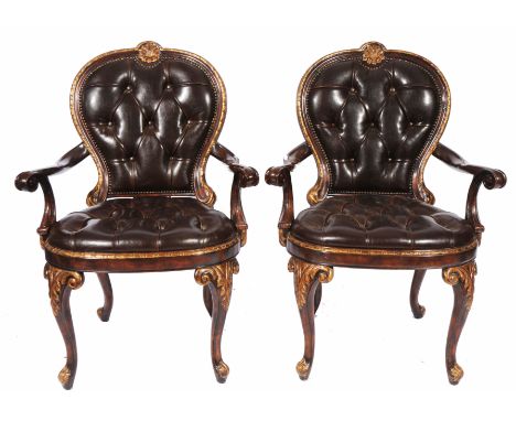 A PAIR OF BROWN BUTTON LEATHER UPHOLSTERED ITALIANATE OPEN ARMCHAIRS, the carved frame with gilt highlights and standing on s