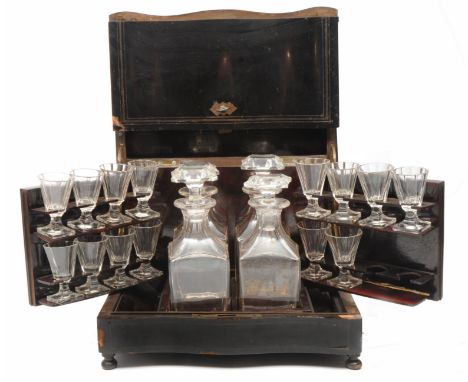 A VICTORIAN EBONISED TABLE TOP LIQUEUR CABINET with serpentine front, the lifting lid opening to reveal  four decanters and m