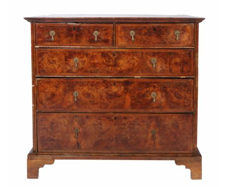 AN 18TH CENTURY WALNUT VENEERED CHEST of two short and three long drawers with brass drop handles and standing on bracket fee