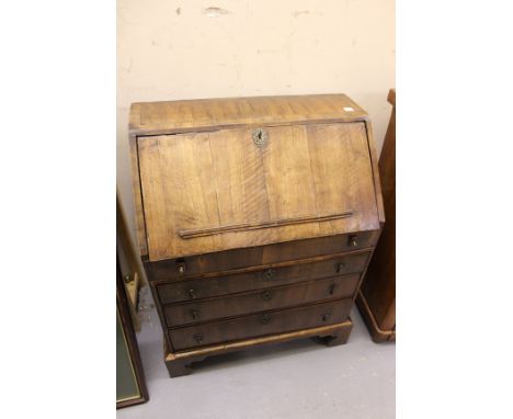 A NORTHERN EUROPEAN WALNUT BUREAU, the fall front opening to reveal drawers, pigeon holes within, all over three graduated bo