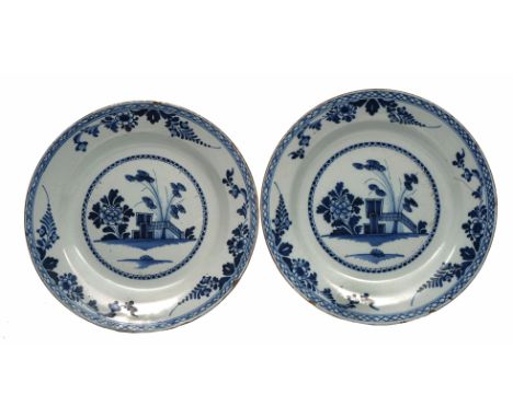 A PAIR OF 18TH CENTURY ENGLISH DELFTWARE BLUE AND WHITE CHARGERS centrally decorated with Camelia, rock work and bamboo withi