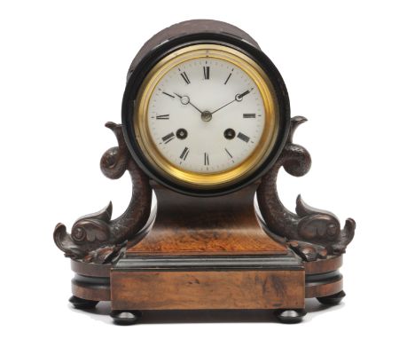 A 19TH CENTURY FRENCH WALNUT CASED MANTLE CLOCK the movement set into a drum with dolphin supports and on a shaped plinth bas